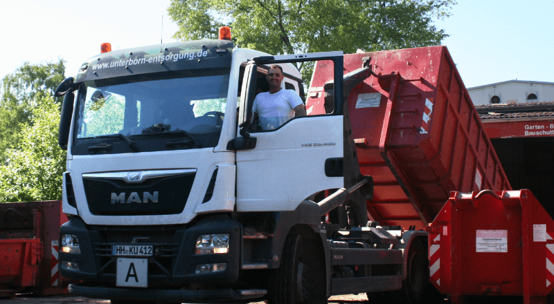 Abbildung zeigt einen LKW Fahrer in seinem Fahrzeug der ablädt